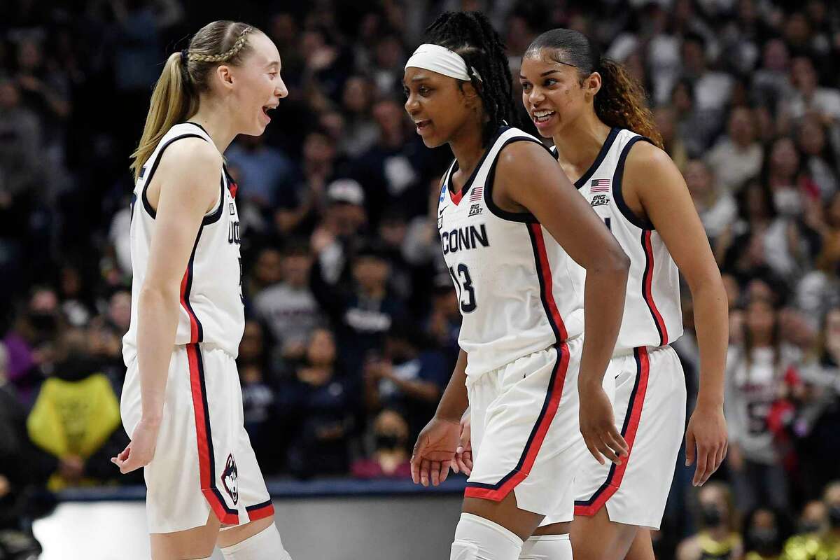 From left, UConn’s Paige Bueckers, Christyn Williams and Evina Westbrook react during Monday’s game against UCF in the second round of the NCAA Tournament.