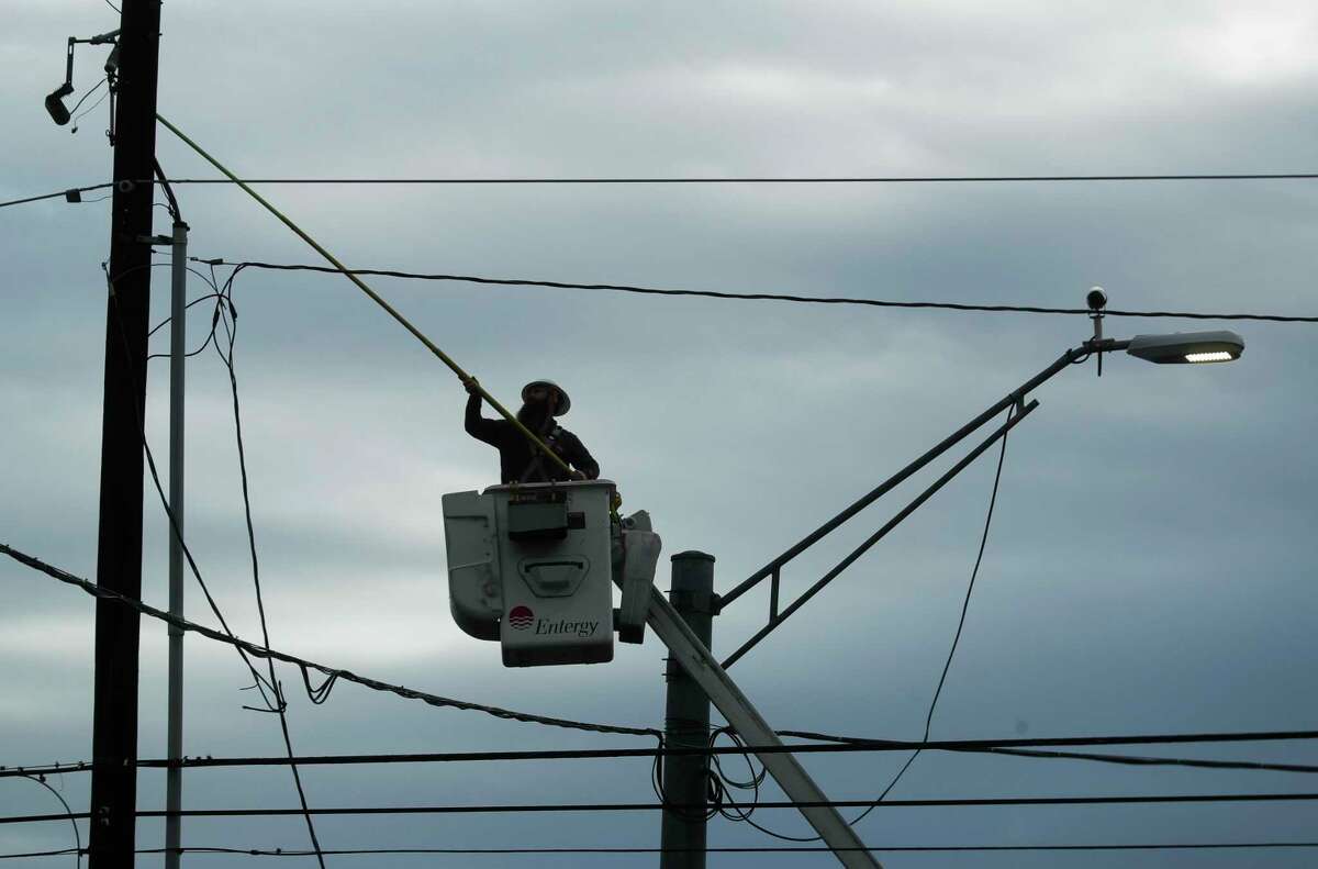 An Entergy employee works on a transformer line along FM 1314 after fast moving storms pummeled areas of Texas overnight, Tuesday, March 22, 2022, in Conroe.