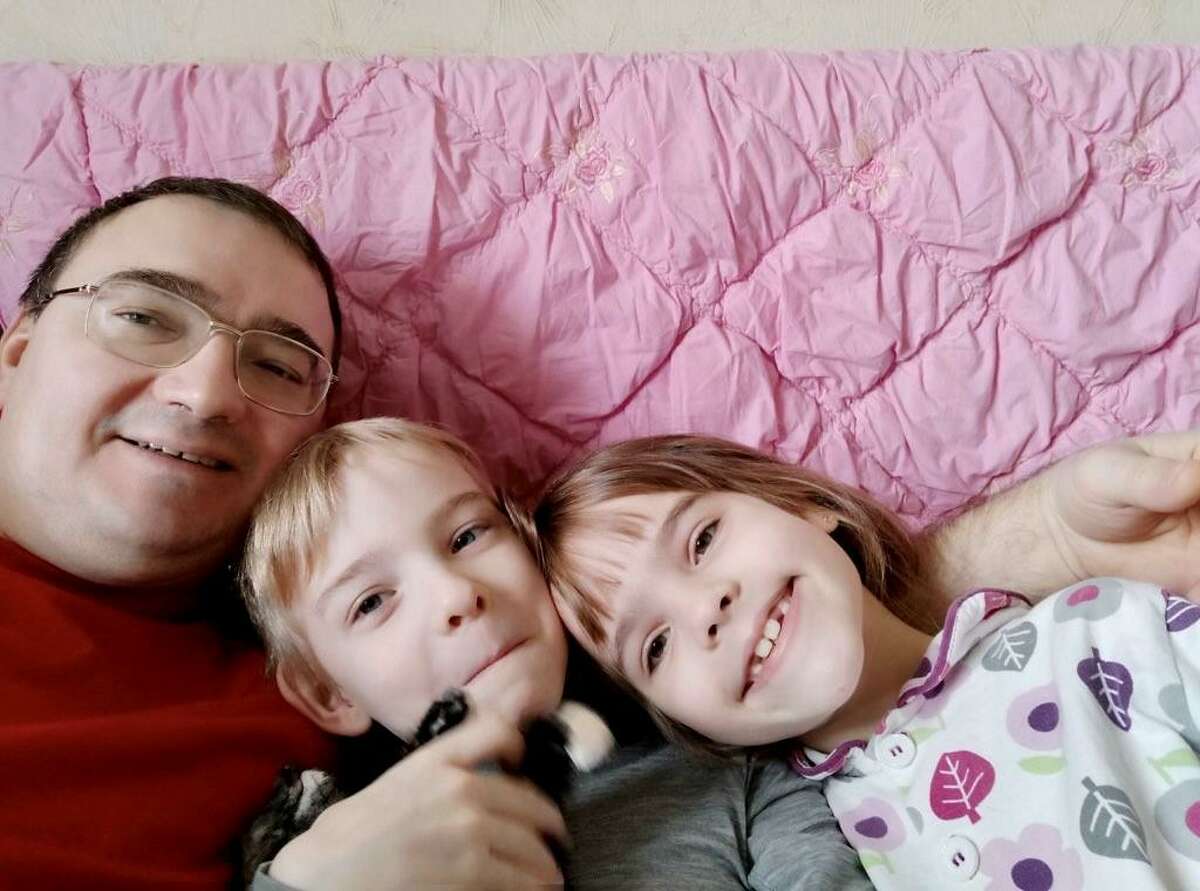 Igor Guriev poses with his twins, Natasha and Kolya, in an undisclosed location in western Ukraine where they are seeking safety from the Russian invasion.