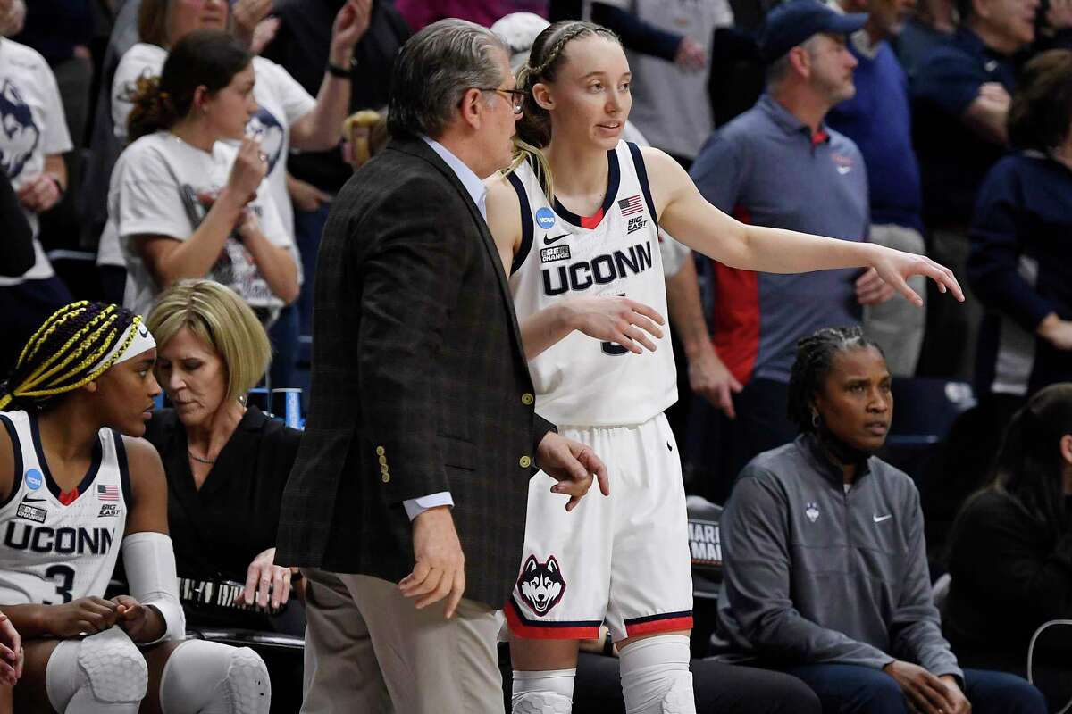 Connecticut head coach Geno Auriemma, left, talks with Connecticut's Paige Bueckers during the second half of a second-round women's college basketball game in the NCAA tournament, Monday, March 21, 2022, in Storrs, Conn. (AP Photo/Jessica Hill)