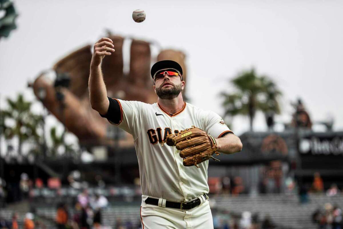 San Francisco Giants’ Darin Ruf tosses a ball after making a diving catch to the end the first inning against the San Diego Padres at Oracle Park in San Francisco, California Thursday, Sept. 16, 2021.