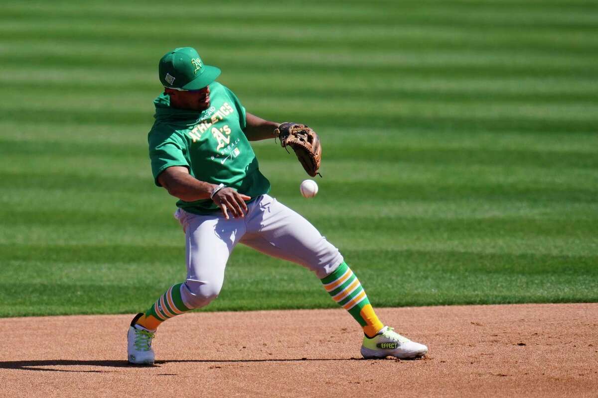 Oakland Athletics second baseman Tony Kemp throws to first base during a baseball spring training workout Wednesday, March 16, 2022, in Mesa, Ariz. (AP Photo/Ross D. Franklin)