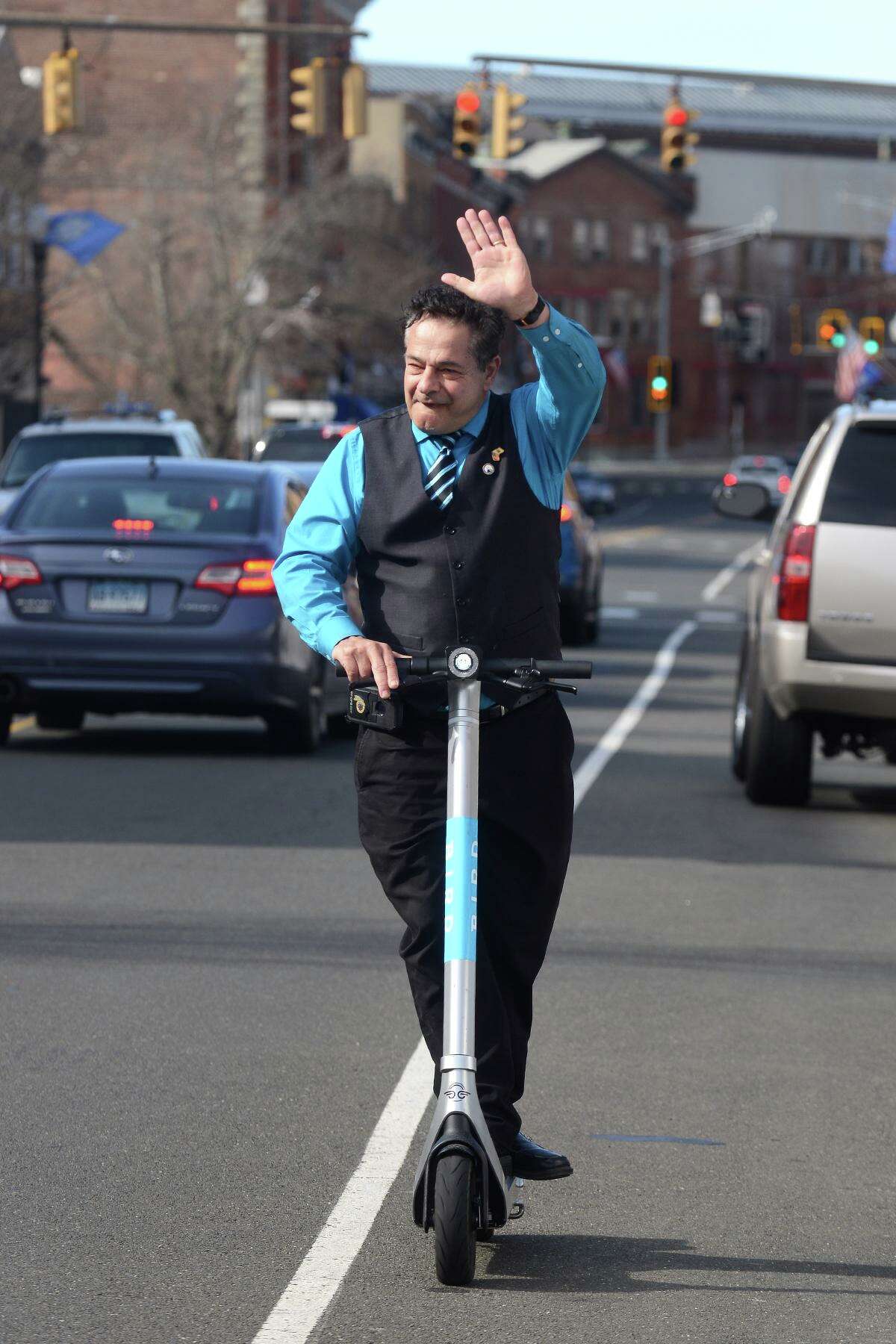 Mayor David Cassetti rides a Bird e-scooter along Main Street during a demonstration event in Ansonia, Conn. March 2022.