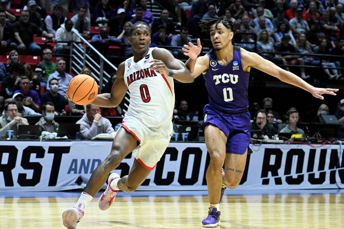 Arizona guard Bennedict Mathurin, left, drives around TCU guard Micah Peavy, right, during the first half of a second-round NCAA college basketball tournament game, Sunday, March 20, 2022, in San Diego. (AP Photo/Denis Poroy)