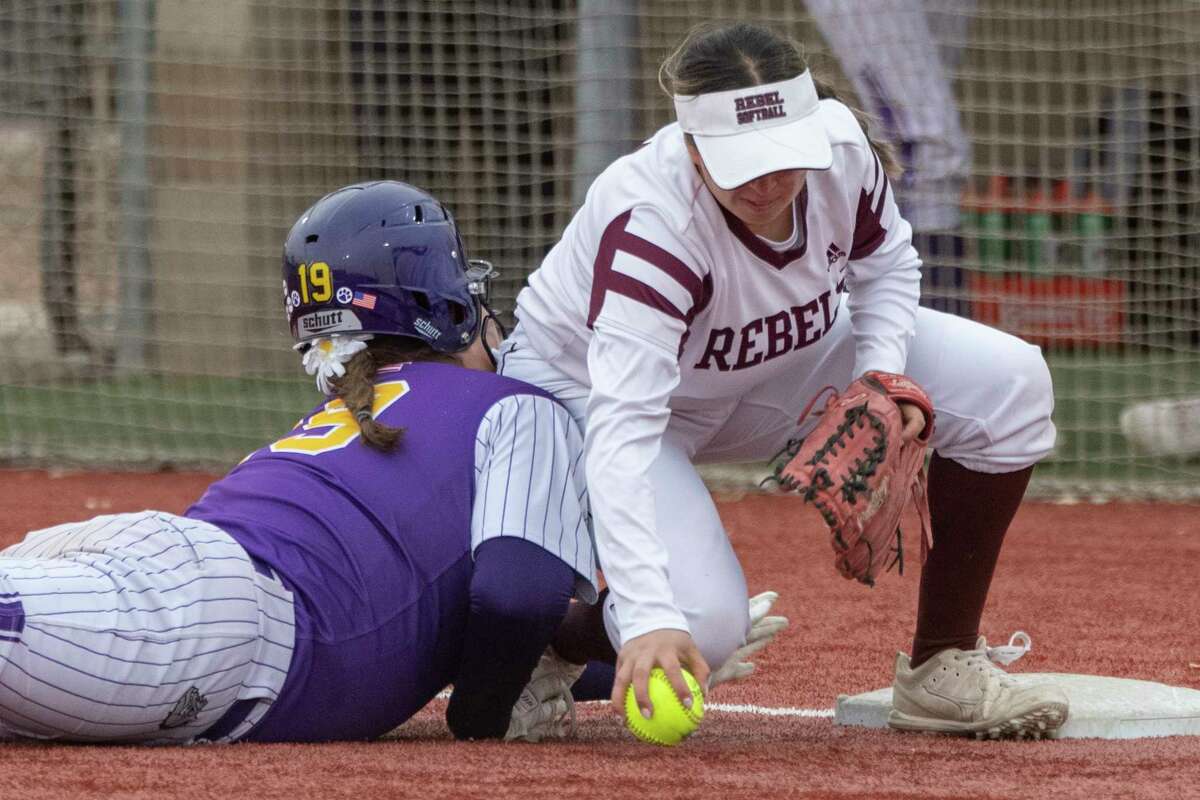 Midland High's Sadie Ryan safely dives back to first on a popup bunt as Legacy High's Alfa Loredo can't handle the throw 03/22/2022 at Gene Smith Field. Tim Fischer/Reporter-Telegram