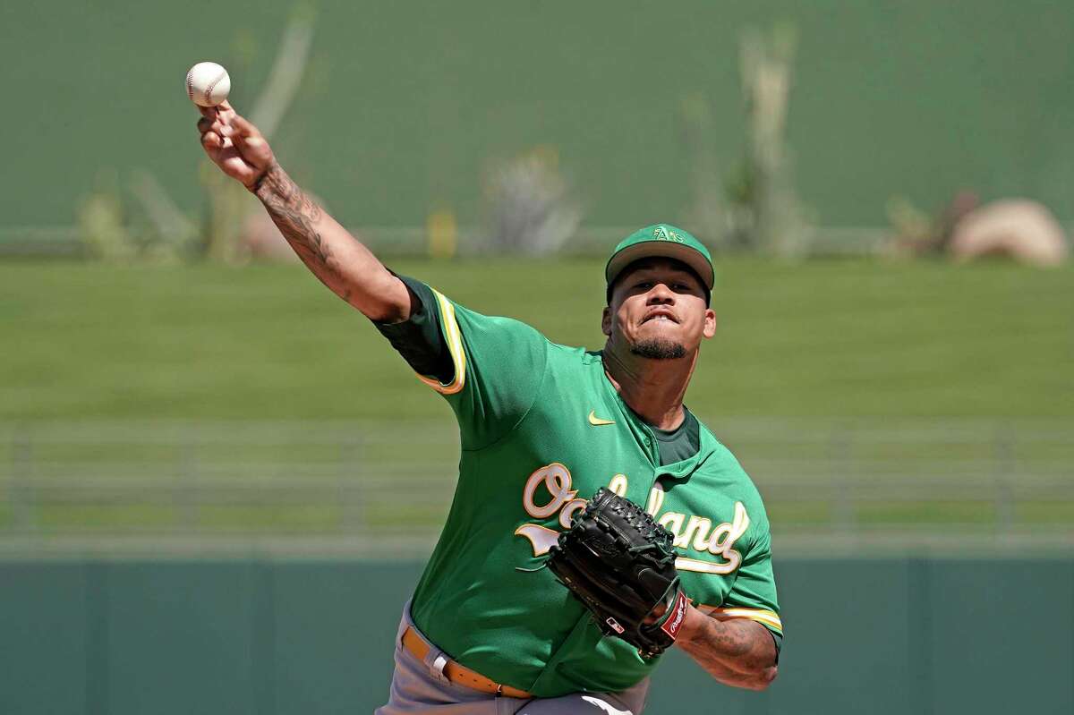 Oakland Athletics starting pitcher Frankie Montas throws during the first inning of a spring training baseball game against the Kansas City Royals Tuesday, March 22, 2022, in Surprise, Ariz. (AP Photo/Charlie Riedel)