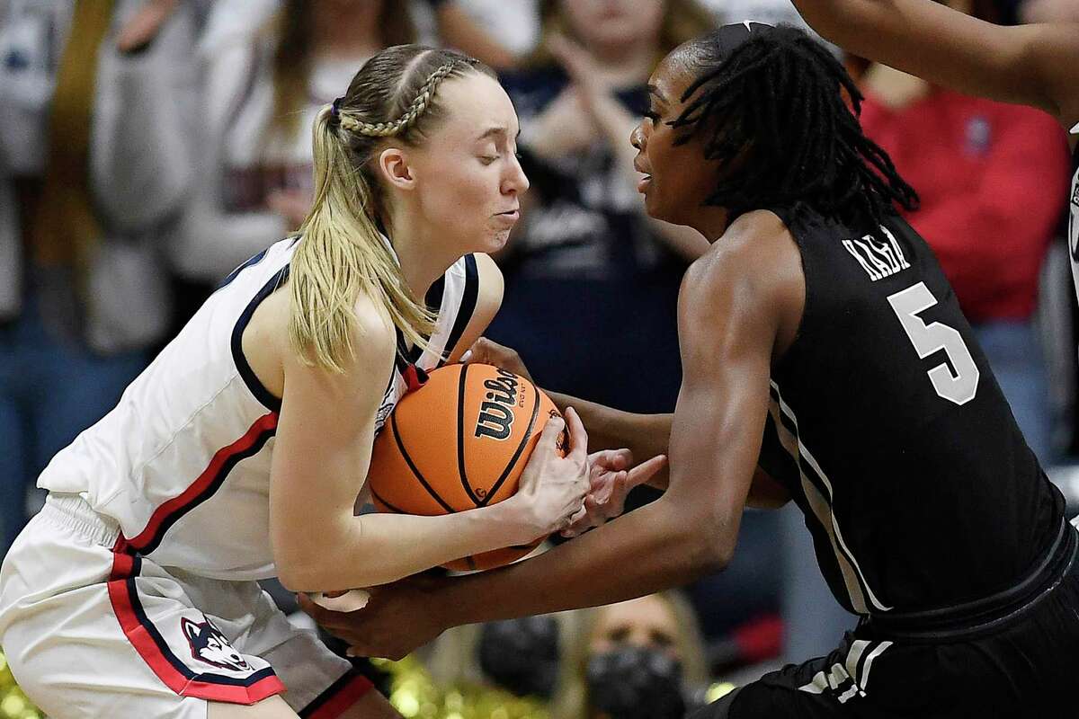 Connecticut's Paige Bueckers, left, steals the ball from Central Florida's Masseny Kaba, right, during the second half of a second-round women's college basketball game in the NCAA tournament, Monday, March 21, 2022, in Storrs, Conn. (AP Photo/Jessica Hill)