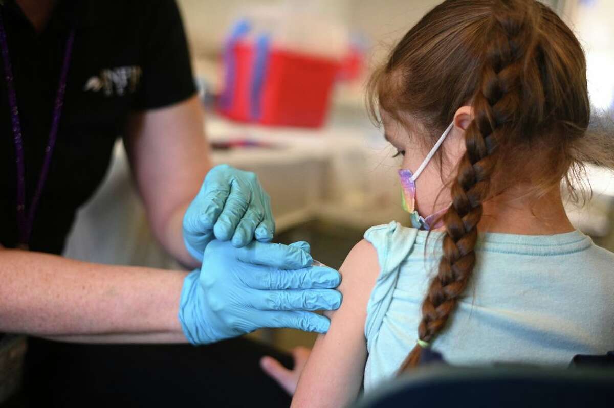 A nurse administers a pediatric dose of the COVID-19 vaccine to a girl at a L.A. Care Health Plan vaccination clinic at Los Angeles Mission College in the Sylmar neighborhood in Los Angeles. (Photo by Robyn Beck/AFP via Getty Images) 