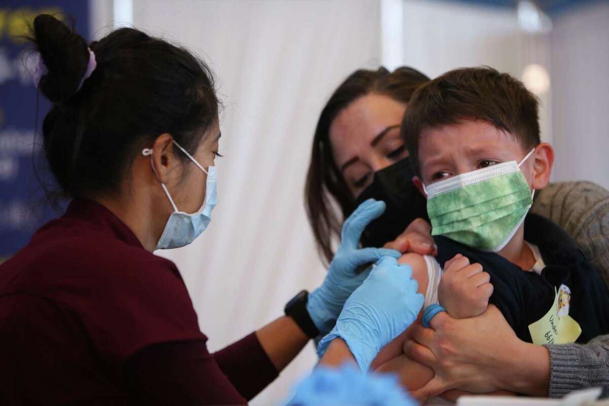 Brayden Mancilla, 7, and his mom sit together as the nurse preps his COVID-19 vaccine shot on March 4, 2022, in San Francisco. The Centers for Disease Control and Prevention has signed off on a vaccine advisory panel’s recommendation to offer booster shots to U.S. children aged 5 to 11.