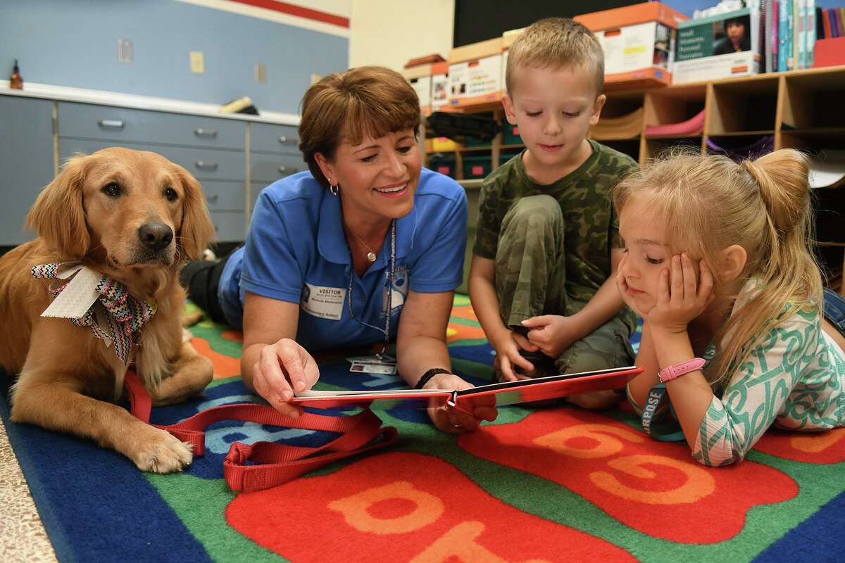 Melinda Blankenship, from left, of Spring, with her therapy dog "Piper", listens as Theiss Elementary kindergartners Emmett Stevens, 6, and Maci Windham, 6, read to "Piper" as part of the Faithful Paws PERK (Pets Enjoy Reading Kids) Program at the school on May 23, 2018. (Jerry Baker/For the Chronicle)