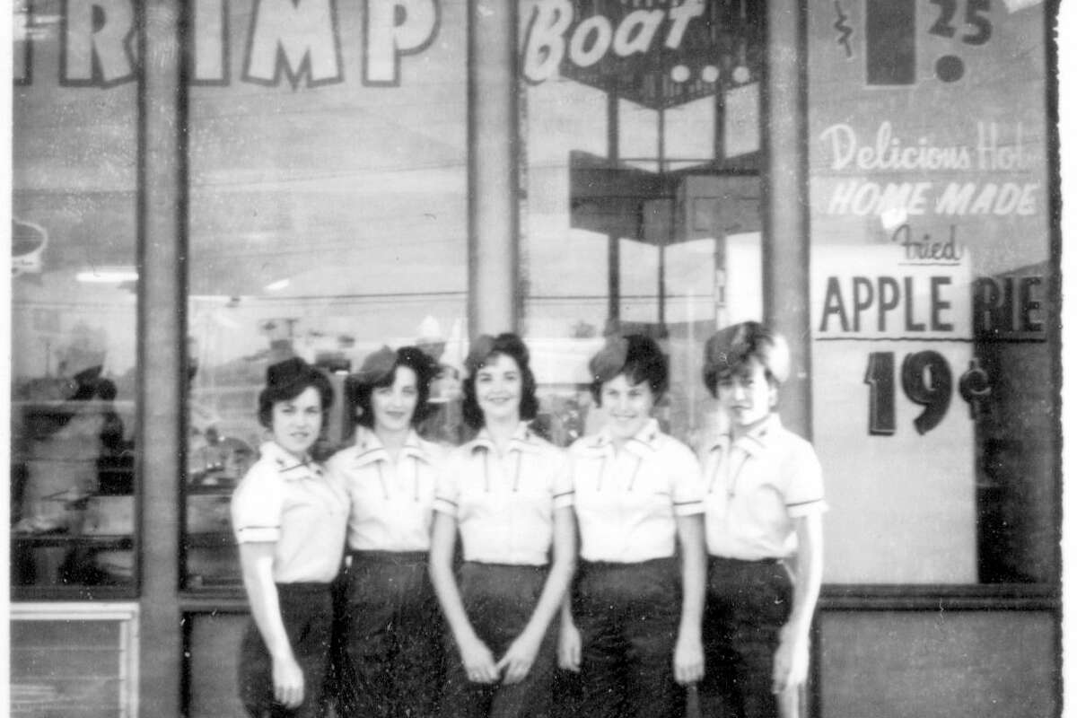 Servers line up in uniforms in front of one of the Frontier Drive-In restaurants.