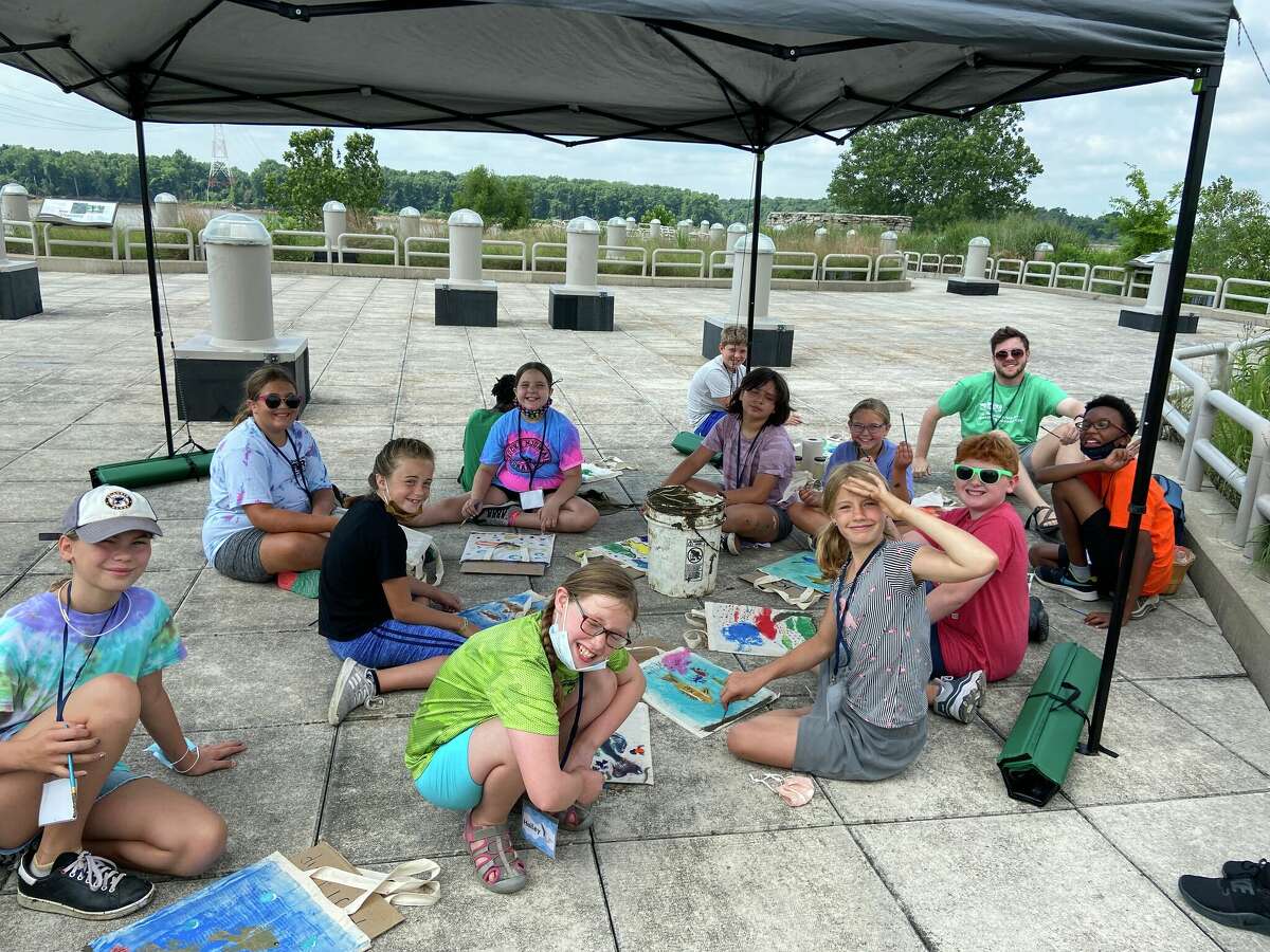 Campers design their fish print tote bags and decorate with Mississippi River mud.