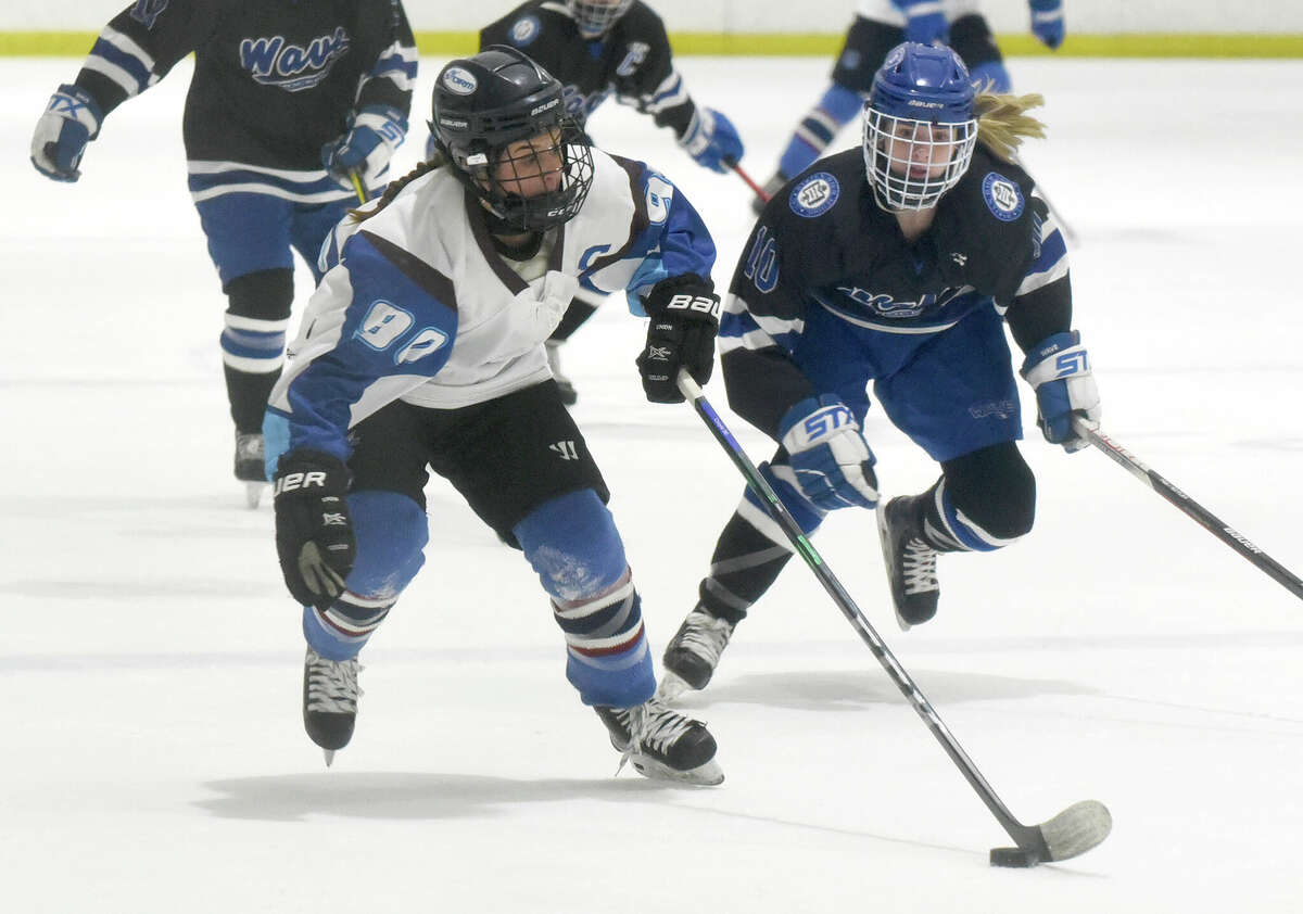 ETB's Meghan Croyle (90) skates with the puck while Darien's Kelsey Brown pursues during a girls ice hockey game at the Darien Ice House on Saturday, Feb. 5, 2022.