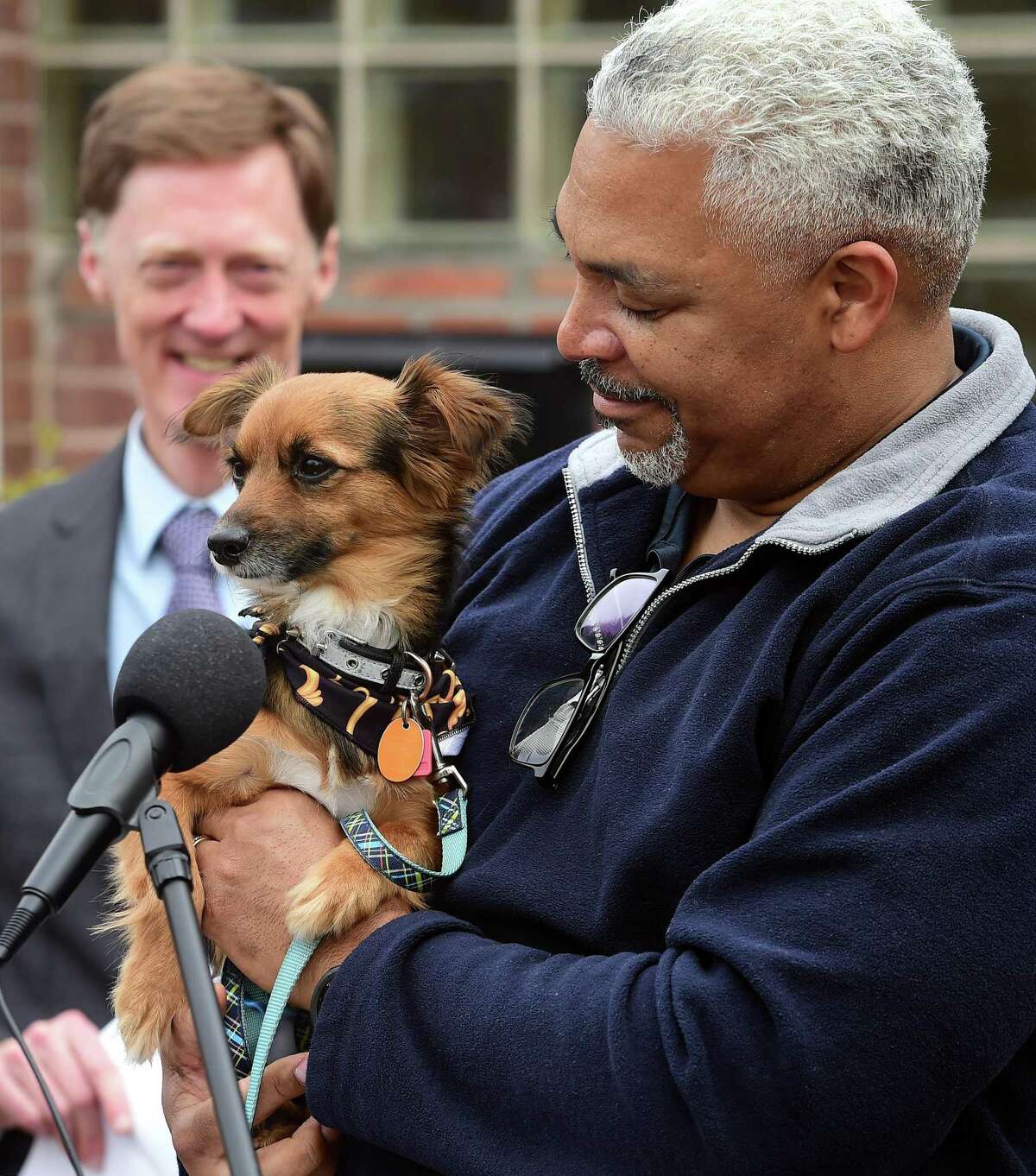 Reginald McGlotten holds his adopted dog, Remi, in front of the Robin I. Kroogman New Haven Animal Shelter on National Puppy Day Wednesday.