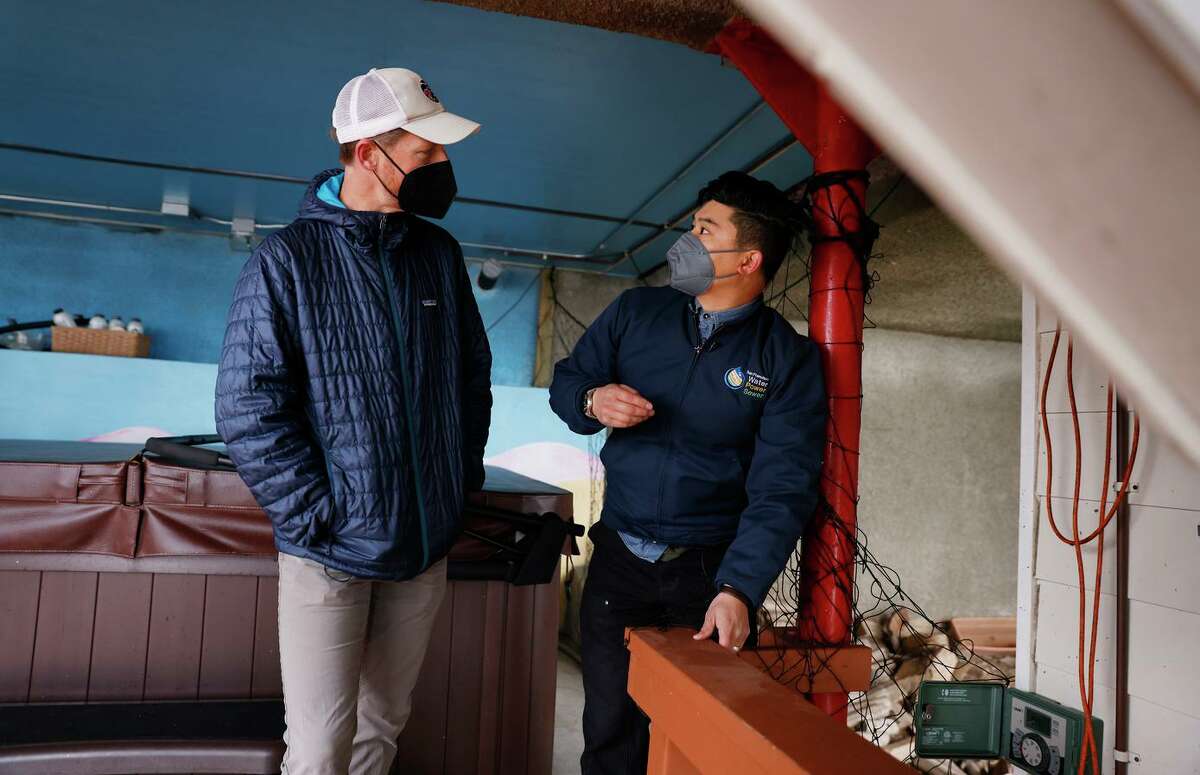 Homeowner Peter Monks (left), talks with Andrew Ho, a water conservation inspector, during a water wise evaluation at Monk’s home on March 23, 2022, in San Francisco, Calif.