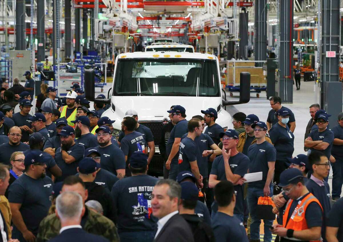 Navistar employees mill about as officials conduct a ribbon cutting ceremony at their new factory on the South Side. The million square-foot facility is expected to produce heavy duty commercial trucks at a rate of 110 vehicles rolling off the line per day. The plant is equipped to produce diesel engine and fully electric vehicles according to Navistar officials.