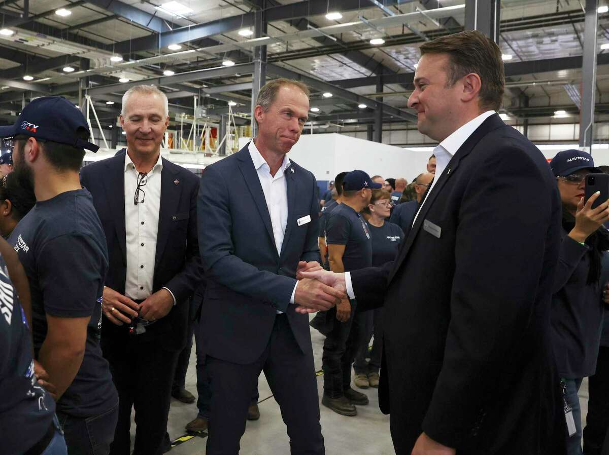 Mathias Carlbaum (center), President and CEO, Navistar shakes hands with Chris Pellico, San Antonio Program Manager, Navistar as the company conducts a ribbon cutting ceremony with local government officials at their new factory on the South Side. The million square-foot facility is expected to produce heavy duty commercial trucks at a rate of 110 vehicles rolling off the line per day. The plant is equipped to produce diesel engine and fully electric vehicles according to Navistar officials.