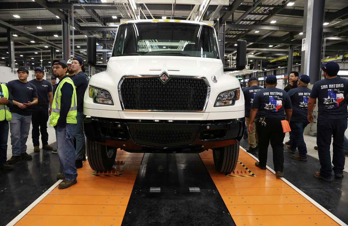 Navistar employees mill about a nearly completed truck as the company holds a ribbon cutting ceremony with local government officials at its new factory on the South Side. The million square-foot facility is expected to produce heavy duty commercial trucks at a rate of 110 vehicles rolling off the line per day. The plant is equipped to produce diesel engine and fully electric vehicles according to Navistar officials.