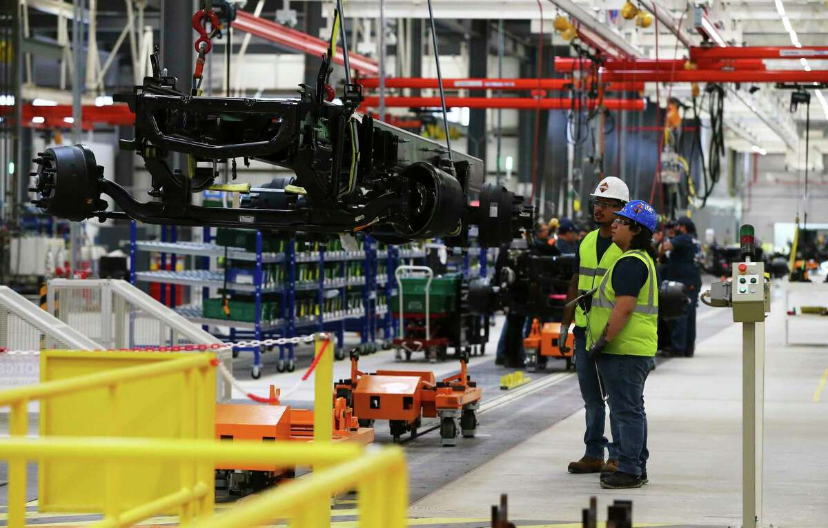 Navistar employees watch a truck frame being transported as the company holds a ribbon-cutting ceremony at its new 900,000-square foot factory on the South Side.