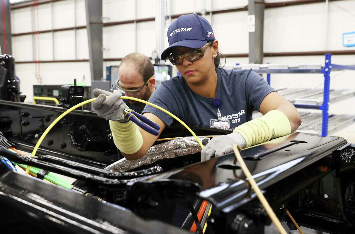 A Navistar employee trains on assembling a vehicle as the company holds a ribbon cutting ceremony with local government officials at its new factory on the South Side. The million square-foot facility is expected to produce heavy duty commercial trucks at a rate of 110 vehicles rolling off the line per day. The plant is equipped to produce diesel engine and fully electric vehicles according to Navistar officials.