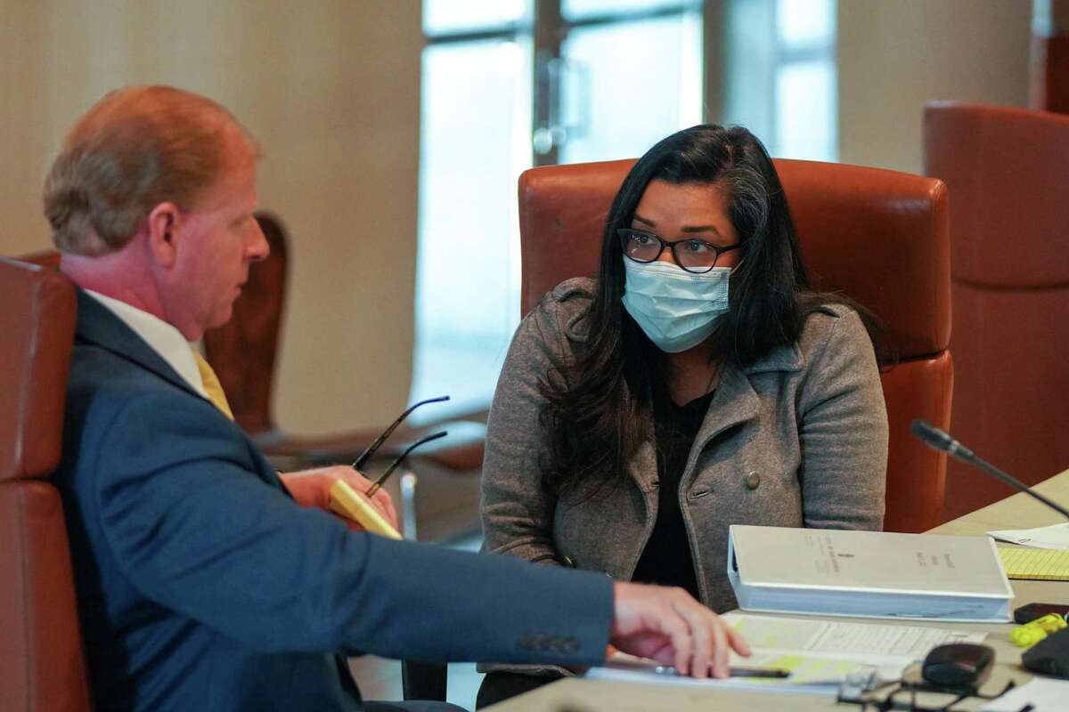 Former San Antonio police officer Elizabeth Montoya speaks with her attorney, Robert Leonard, on Tuesday during an arbitration hearing in her appeal of an indefinite suspension from the San Antonio Police Department.