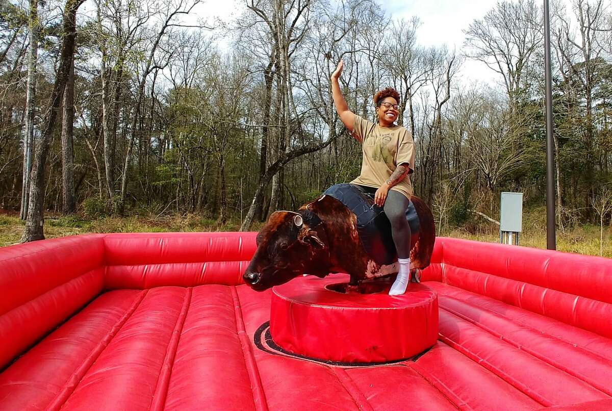 An Azalea Festival goer enjoys a ride on the mechanical bull