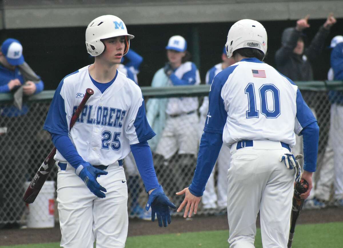 Marquette's Hayden Grammer congratulates teammate Owen Williams after he scored during the second inning against Father McGivney on Wednesday in Alton.