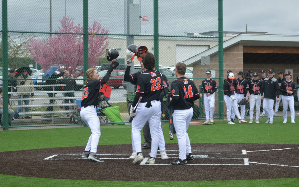 Teammates Grant Huebner (23), Riley Iffrig (22) and Caleb Copeland (14) celebrate with Spencer Stearns after his two-run home run in the first inning gave the Tigers the lead.