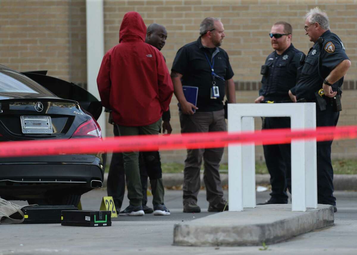 Harris County Sheriff's Office deputies investigate the scene of an attempted robbery of an armored car at the Comerica Bank at 855 FM 1960 on Wednesday, March 23, 2022, in Houston. Three armed suspects fired at an armored car guard who had been servicing an ATM machine, the guard fired back.