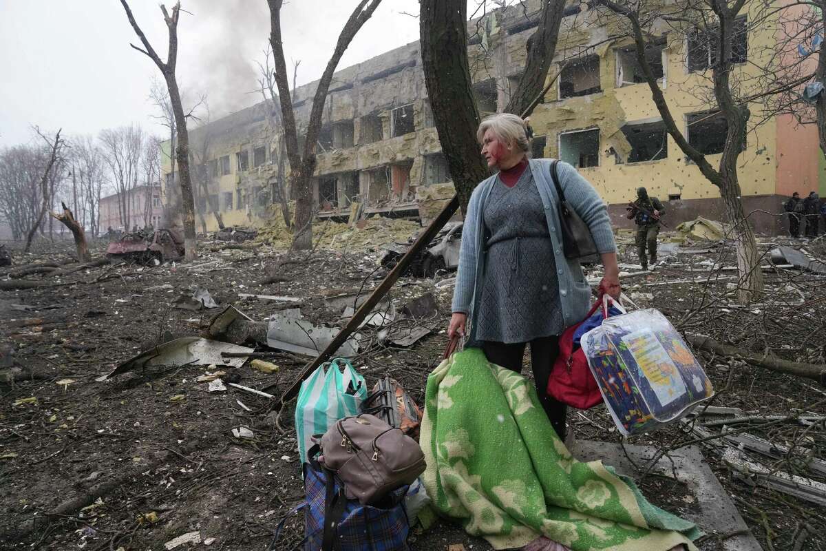 A woman walks outside a maternity hospital that was damaged by shelling in Mariupol, Ukraine oon Wednesday, March 9, 2022. 