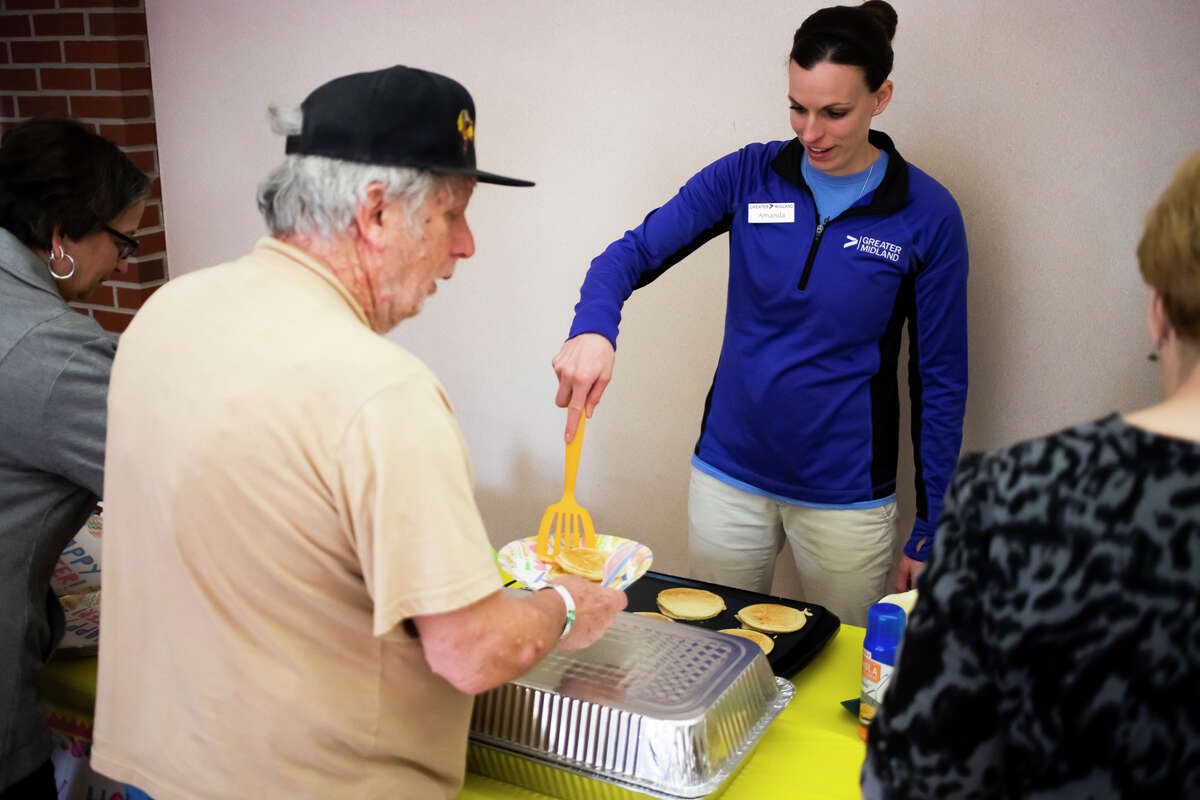 Amanda Ewald, right, serves fresh pancakes during a pancake breakfast for seniors at the Greater Midland Community Center Monday, March 21, 2022 in Midland.