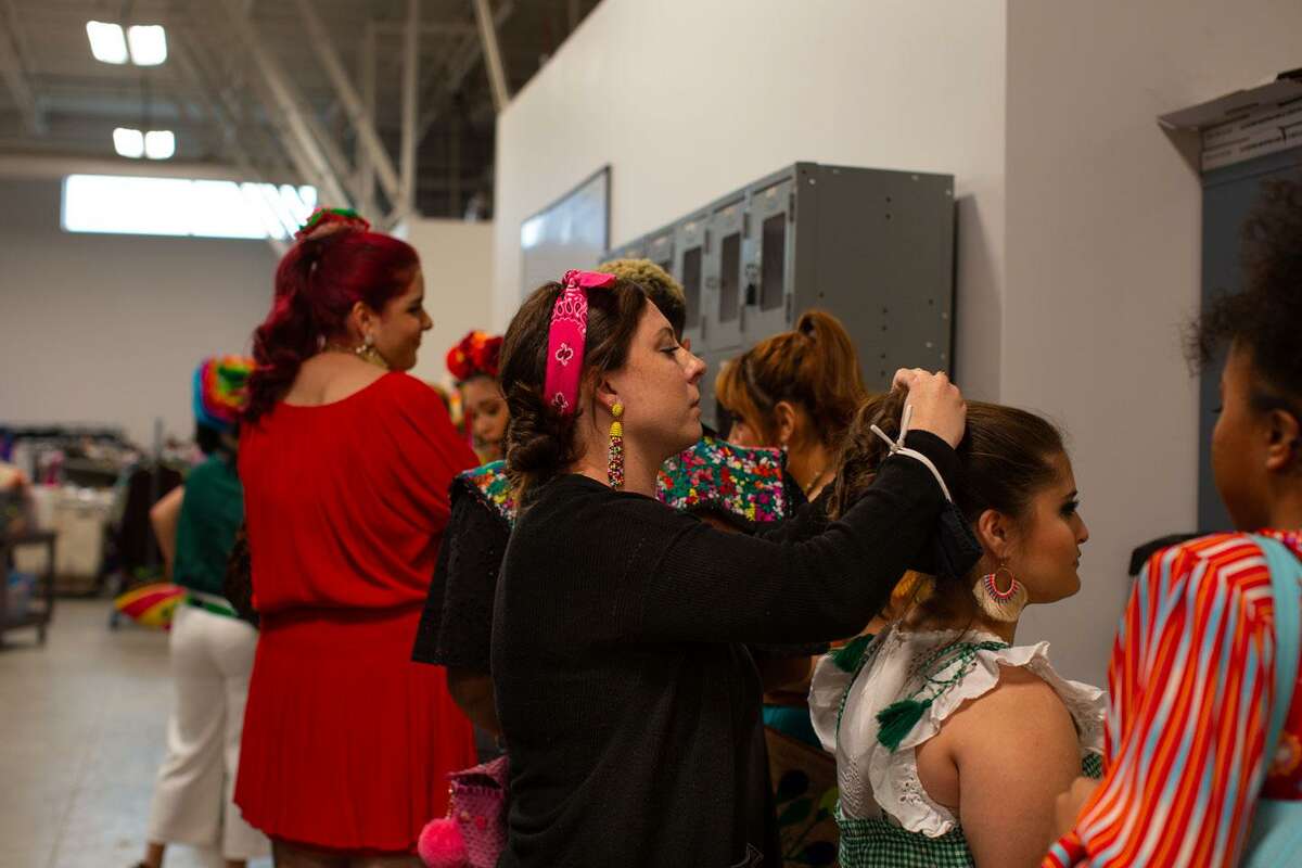Jessica Gomez, a Stevens High School fashion teacher assisting with hair and makeup before Wednesday’s fashion show, tinkers with senior Hannah Siller’s ponytail. (Kaylee Greenlee Beal/Contributor)