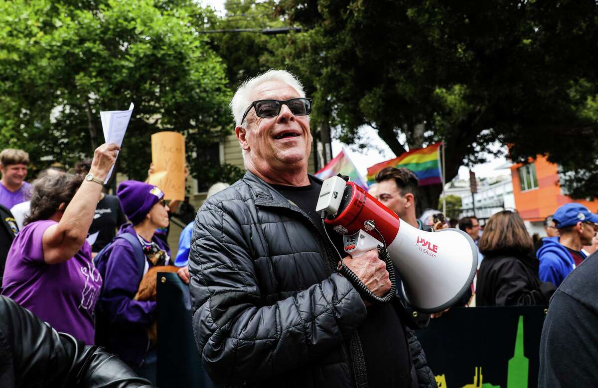 Cleve Jones, a friend of the late Harvey Milk, uses a bullhorn to call his friend Allan Baird after leading a march from Harvey Milk Plaza to Baird's home on Friday, June 25, 2021, in San Francisco, Calif. 