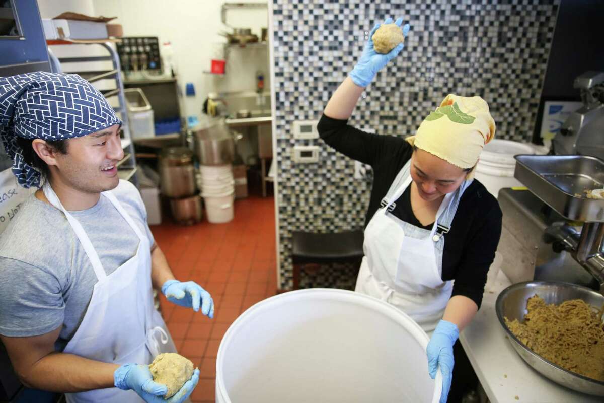 Eleana Hsu and Kevin Gondo, the couple behind Shared Cultures work together to prepare a 30 gallon bucket with the koi rice, soybean and morel mushroom mixture on Tuesday, March 22, 2022, in San Francisco, Calif.