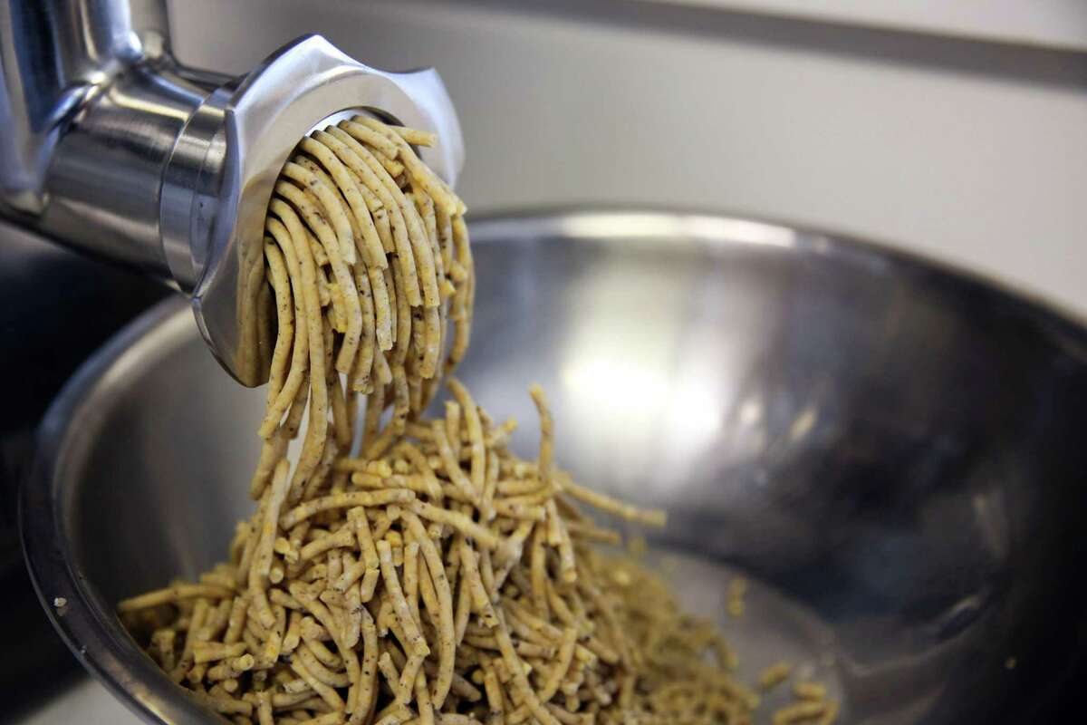 Eleana Hsu uses a meat grinder to process koji rice, beans and morel mushrooms for Shared Cultures miso.