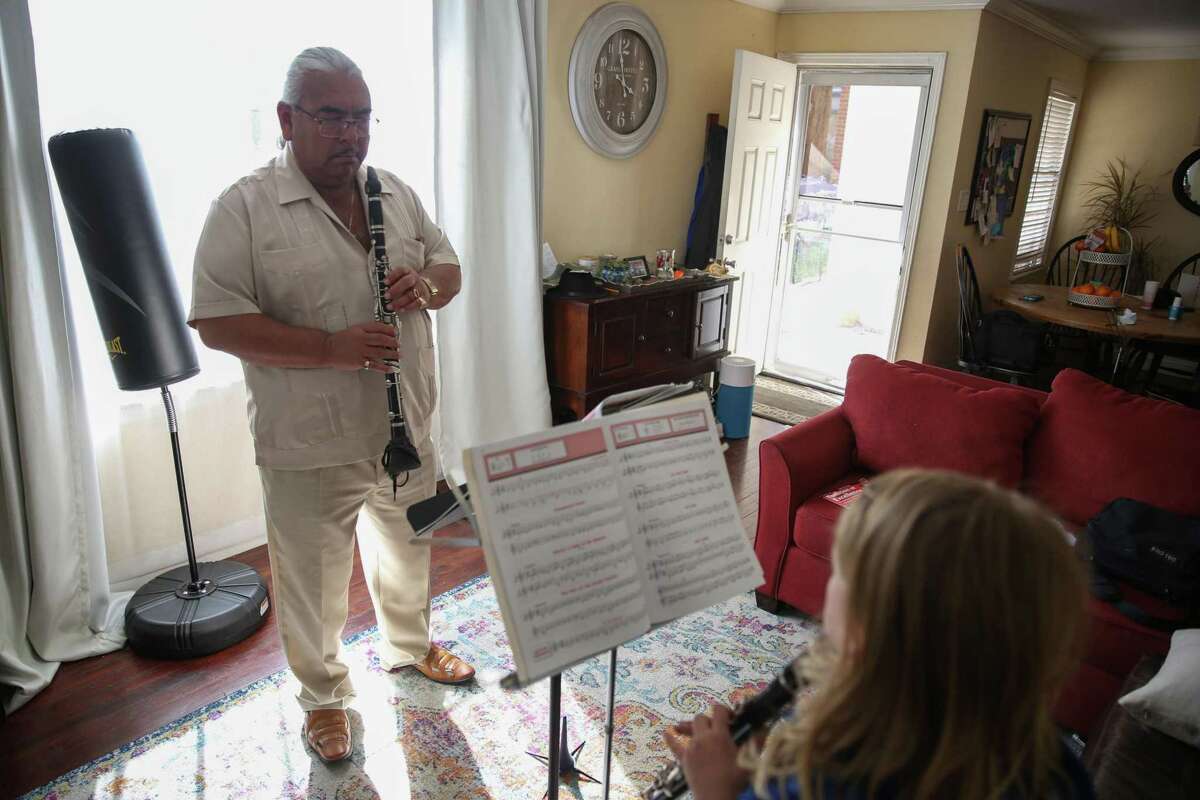Andrés Soto plays clarinet with his youngest grandson. Soto is raising concerns about the effects of pollution, including on his 10-year-old grandson, who has asthma.