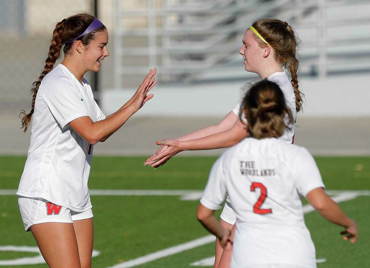 The Woodlands' Ryley Graves, right, celebrate after Natasha Budisa’s goal in the first period of a Region II-6A bi-district high school soccer match at Woodforest Bank Stadium, Thursday, March 24, 2022, in Shenandoah.