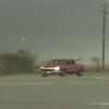 A video uploaded by storm chaser Brian Emfinger shows a red truck getting tossed on its side from tornado winds before driving away. 