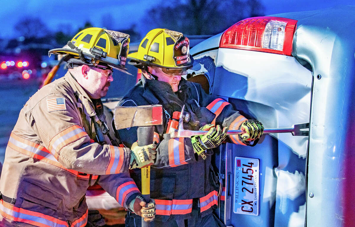 Glen Carbon Fire Protection District Lt. Gregory "Bubba" DeSutter and Lt. Jason Reaka work to pry open the rear hatch of Kia SUV Thursday night during a traffic crash training drill. The real-time exercise, conducted on West Main Street at Route 157 in Glen Carbon, involved a simulated, multi-vehicle accident with multiple casualties trapped in the wreckage. Victims in various states of injury were portrayed by live actors and mannequins. Alongside Glen Carbon, firefighters and EMS workers from Edwardsville and Maryville, among many other agencies, participated in the exercise. 