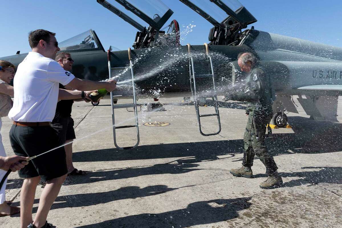 Retired Maj. Theodore Sienicki, who was a prisoner of war in Vietnam, is sprayed with Champagne by family members after completing his “fini” flight at Joint Base San Antonio-Randolph.