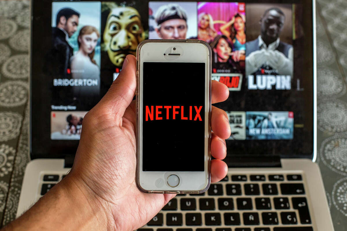 SPAIN - 2021/03/23: In this photo illustration the Netflix app seen displayed on a smartphone screen with the Netflix website on a pc in the background. (Photo Illustration by Thiago PrudÃªncio/SOPA Images/LightRocket via Getty Images)