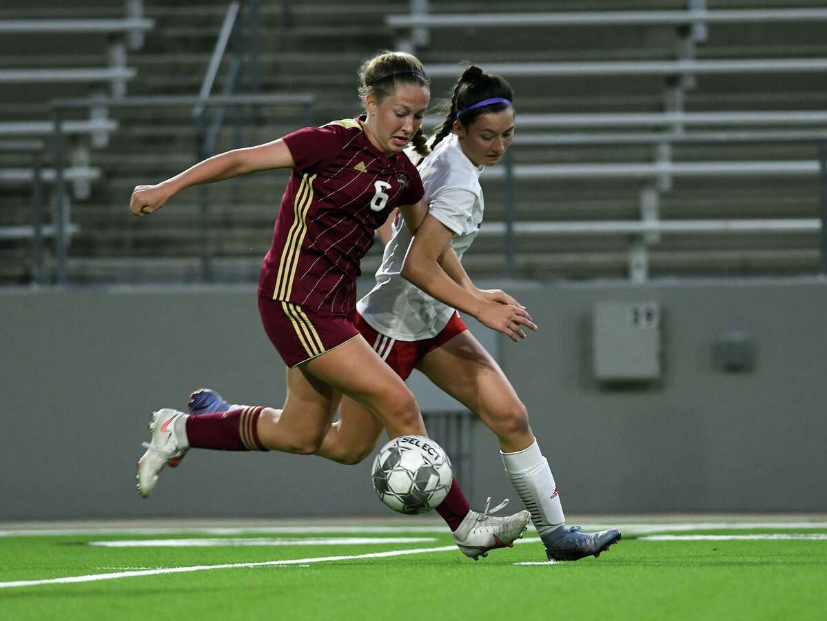 Cy Woods senior midfielder Alex Reilly (6) battles for the ball against Tomball freshman defender Emily Fowlkes during the first period of their Region II-6A Bi-District Playoff matchup at the Berry Center in Cypress on March 24, 2022.