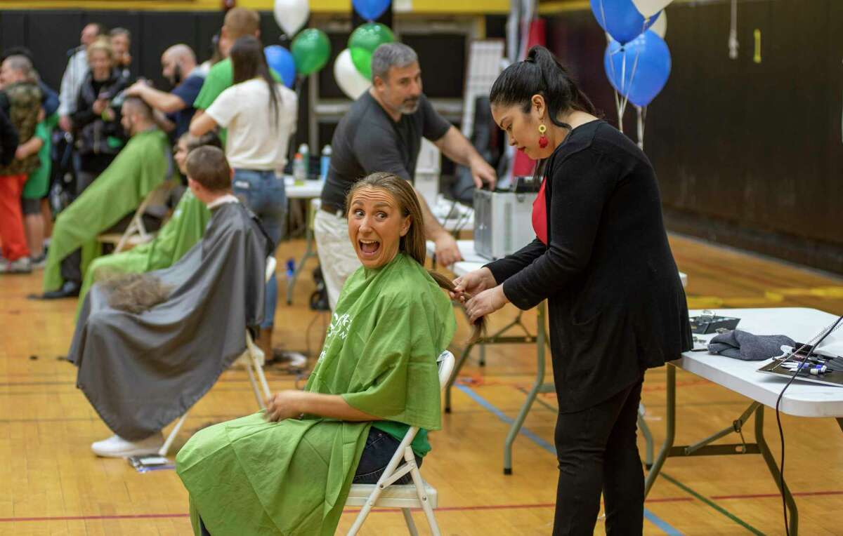 Tyler Mecozzi, an eighth-grade science teacher at Western Middle School, looks at her family as her hair is tied before she got a haircut as part of the St. Baldrick’s cancer fundraiser last month.
