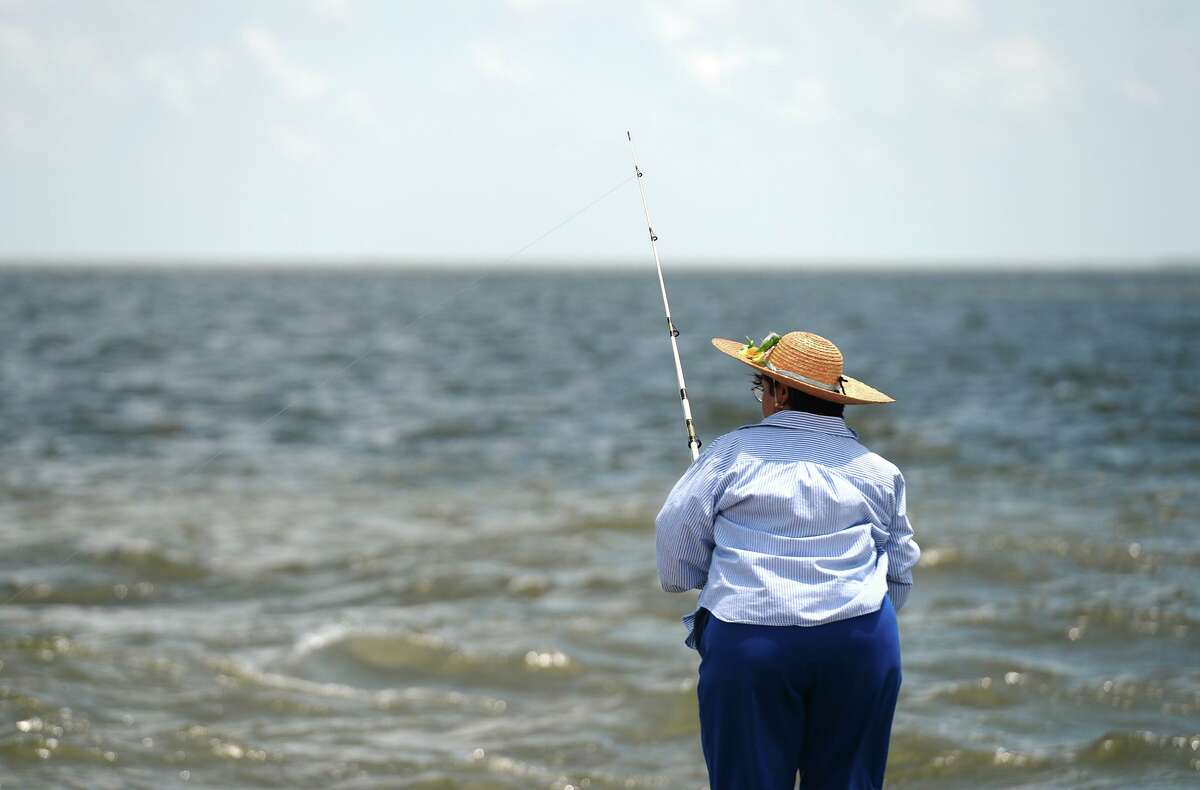 Aurora Gutierrez waits for a fish to bite at Sabine Lake on Saturday afternoon. Warm weather brought anglers out to the water's edge on Pleasure Island on Saturday. The Saltwater Anglers League of Texas also held a Fishing Rodeo event over the weekend. Photo taken Saturday 5/24/14 Jake Daniels/@JakeD_in_SETX