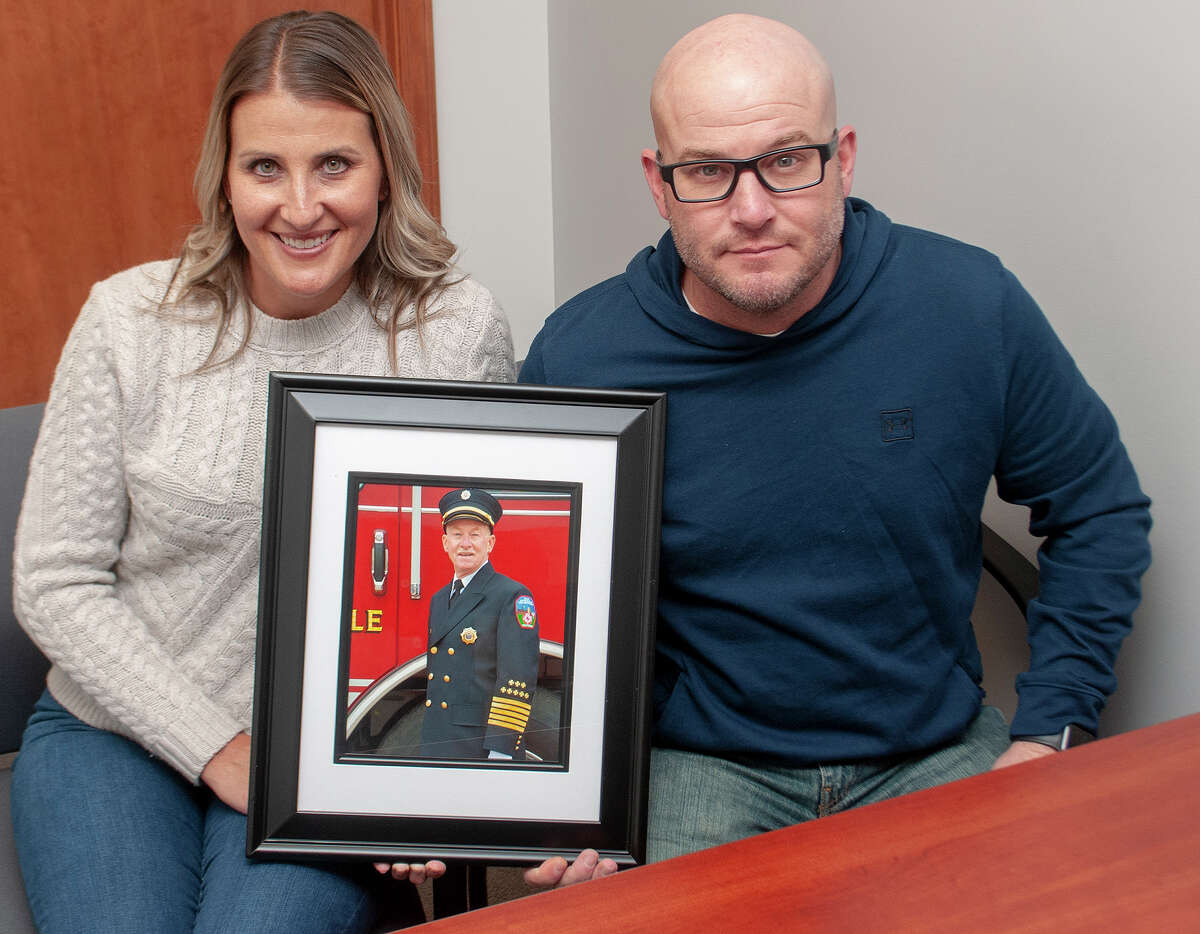Cortney Bonjean (left) and Jason Hickox hold a photo of their father, David Hickox. David Hickox, who died Thursday, spent 40 years as a volunteer for South Jacksonville Fire Department, much of that time as chief.