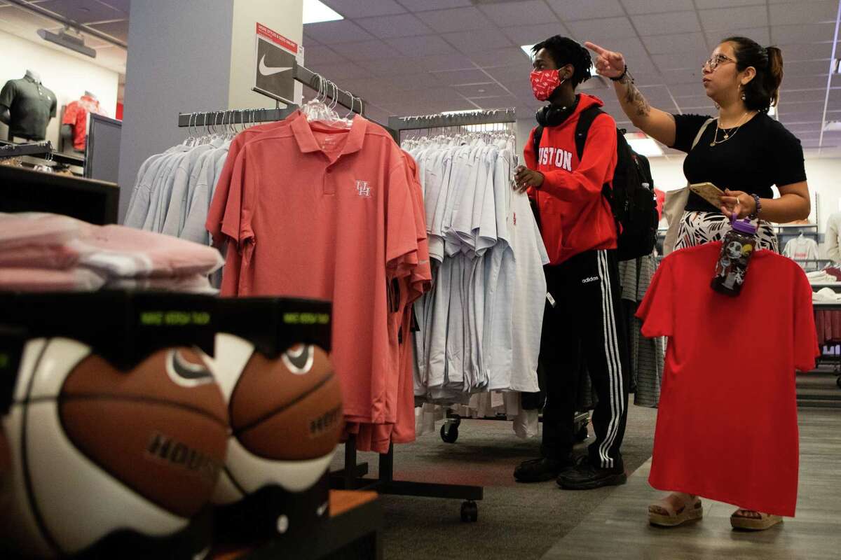 University of Houston students Jimmieonte Applewhite, left, 19, and Maria Godinez, 21, shop for UH merchandise, Friday, March 25, 2022, in Houston, ahead of the Elite Eight game between Houston Cougars and Villanova Wildcats in San Antonio on Saturday.