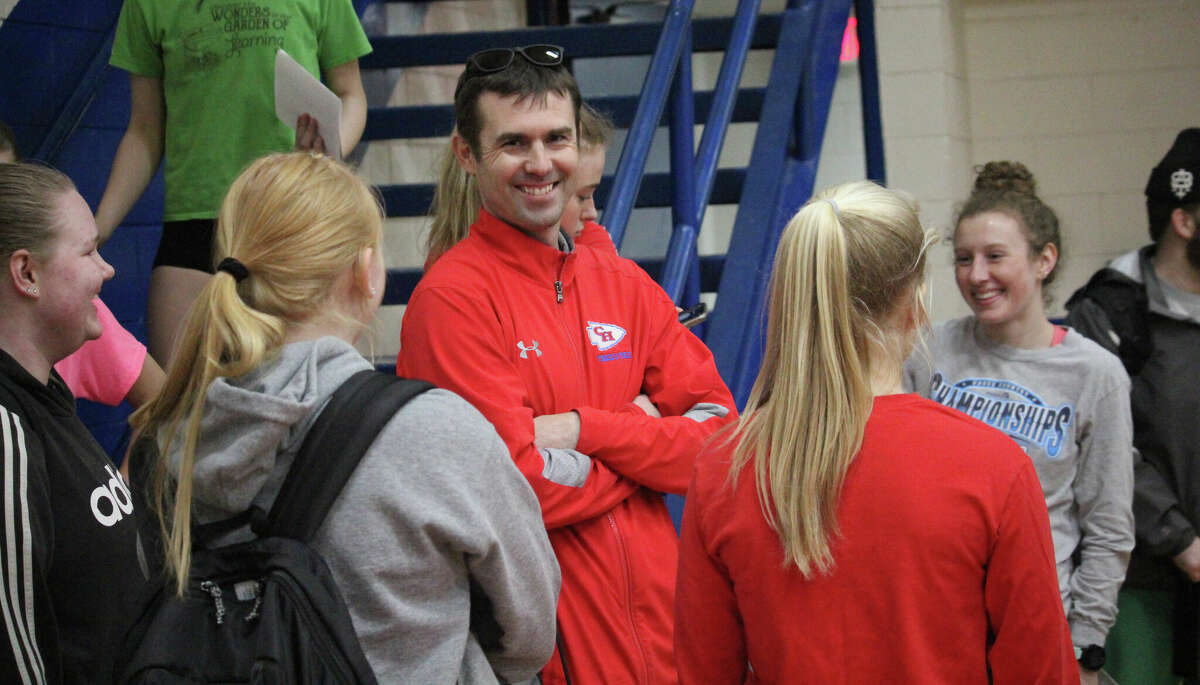 Zach Hatfield (center) and his girls track team have a chat in the Chippewa Hills gym after Friday's practice.
