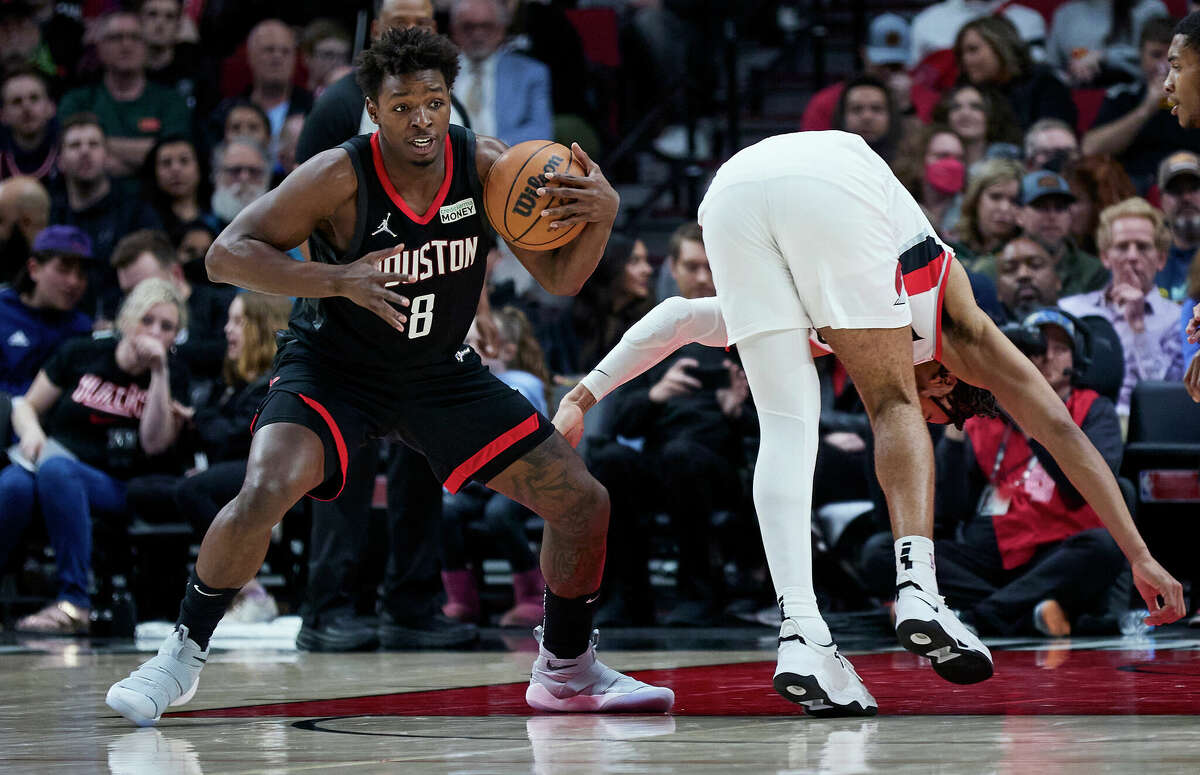 Houston Rockets forward Jae'Sean Tate, left, takes the ball away from Portland Trail Blazers forward Trendon Watford during the second half of an NBA basketball game in Portland, Ore., Friday, March 25, 2022. (AP Photo/Craig Mitchelldyer)