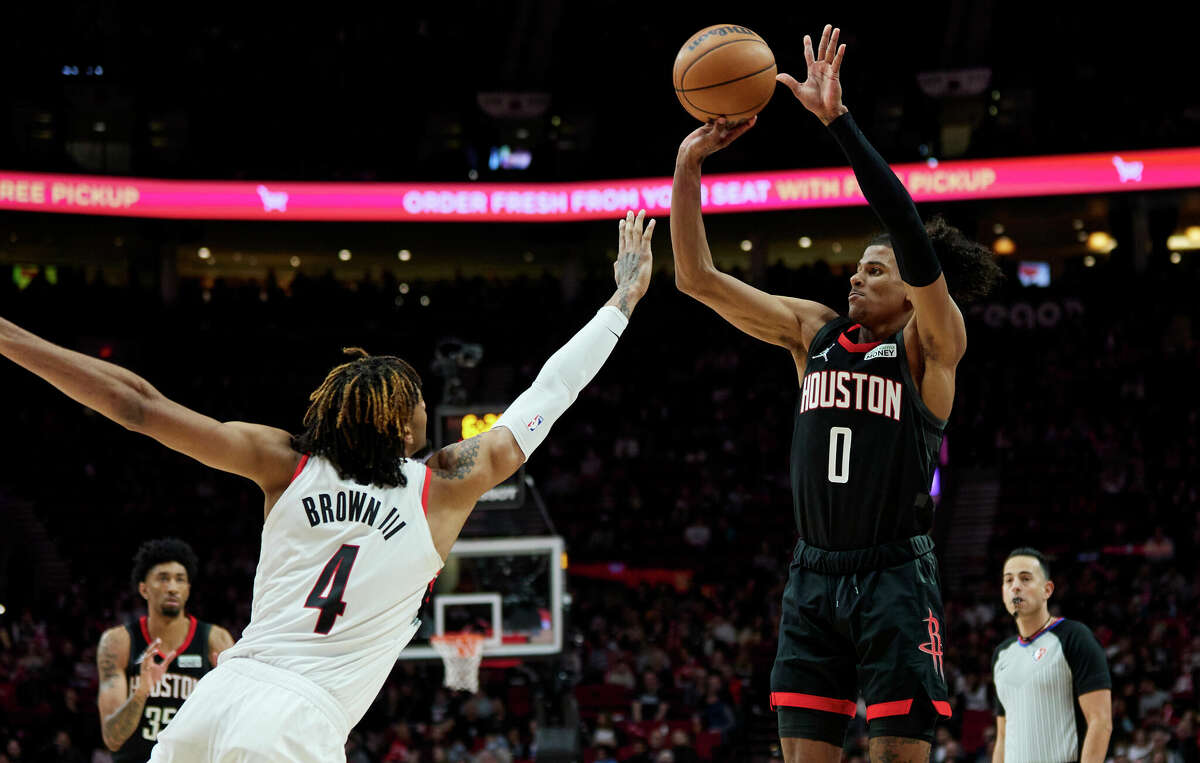 Houston Rockets guard Jalen Green, right, shoots over Portland Trail Blazers forward Greg Brown III during the second half of an NBA basketball game in Portland, Ore., Friday, March 25, 2022. (AP Photo/Craig Mitchelldyer)