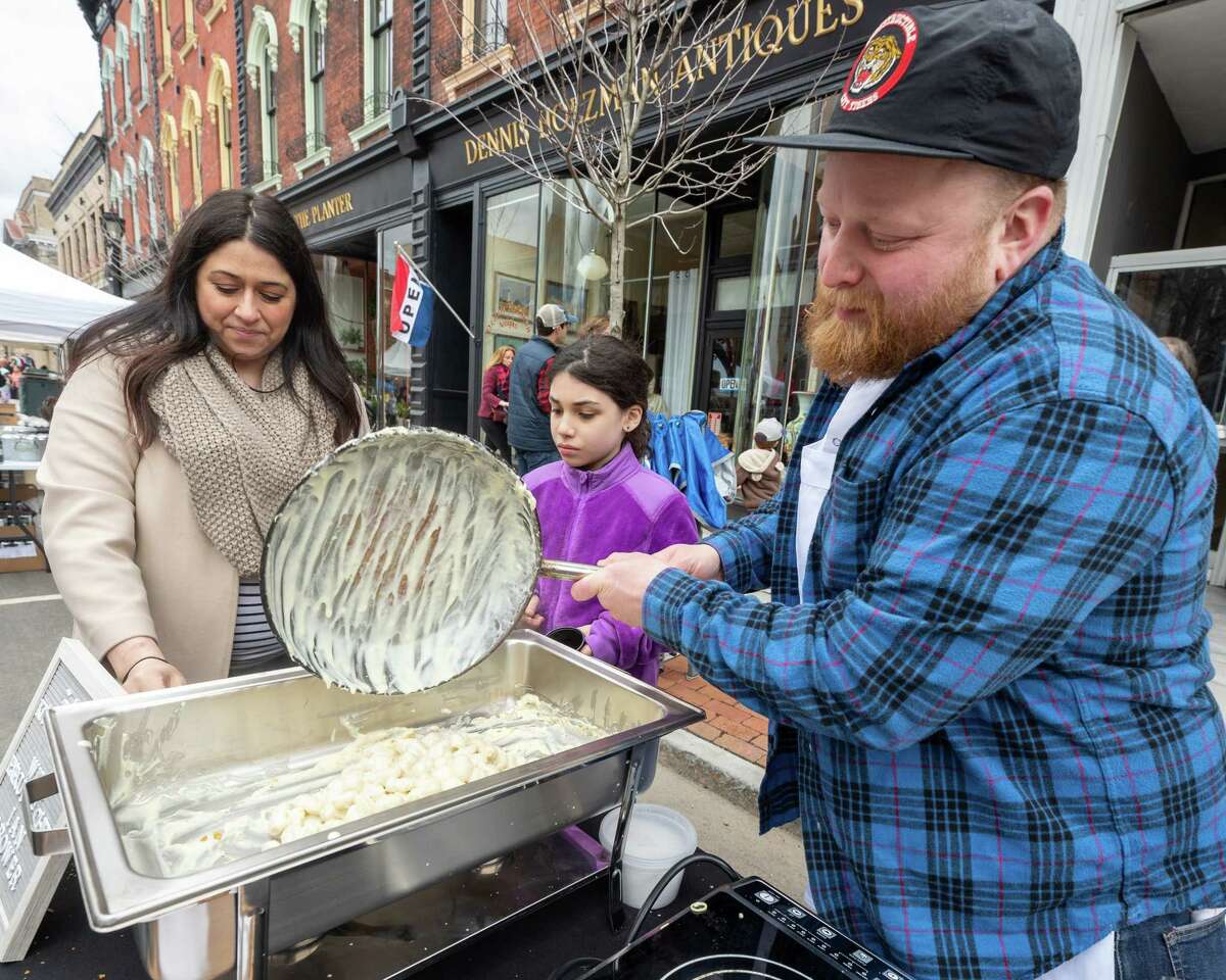 (right to left) Ian Brower, Soli Leanza-Backus and Liz McCann prepare mac-n-cheese at the Kitchen Table booth during the Mac-n-Cheese Bowl, which returned after a two-year hiatus on Saturday, March 26, 2022. It was held outside for the first time on Remsen Street in Cohoes and proceeds benefit the Regional Foodbank of Northeastern New York. (Jim Franco/Special to the Times Union)